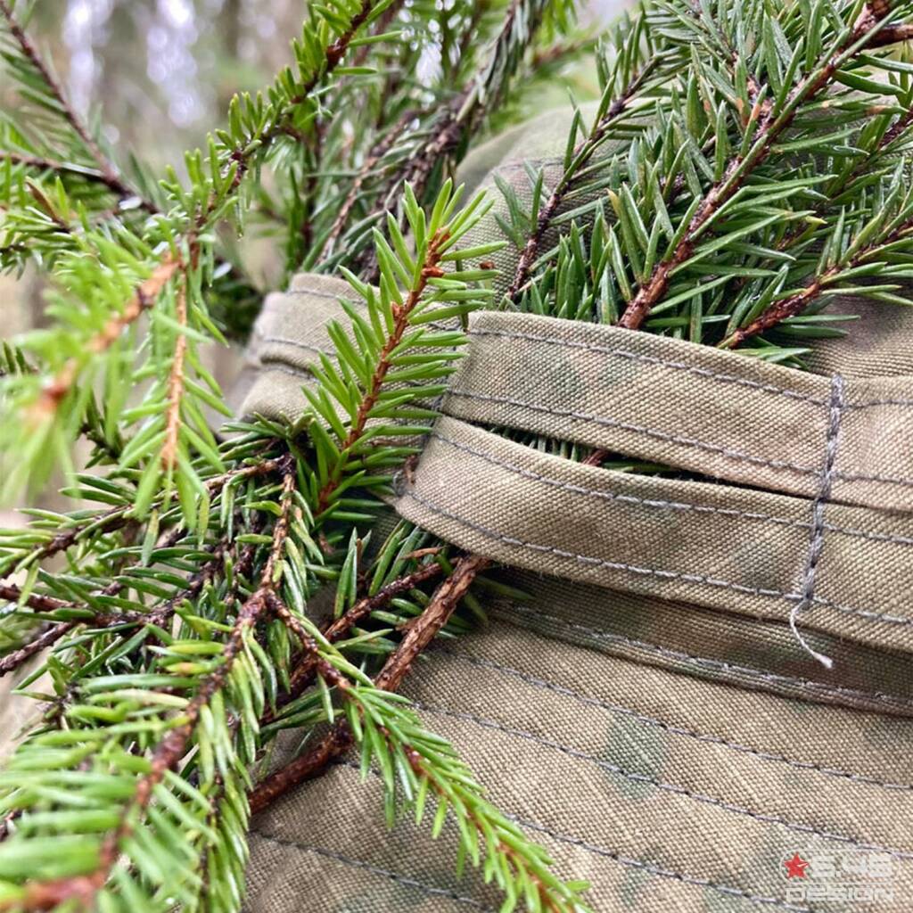 There are special slots all over the hat that enable mounting of camouflage materials: branches, grass, etc.   